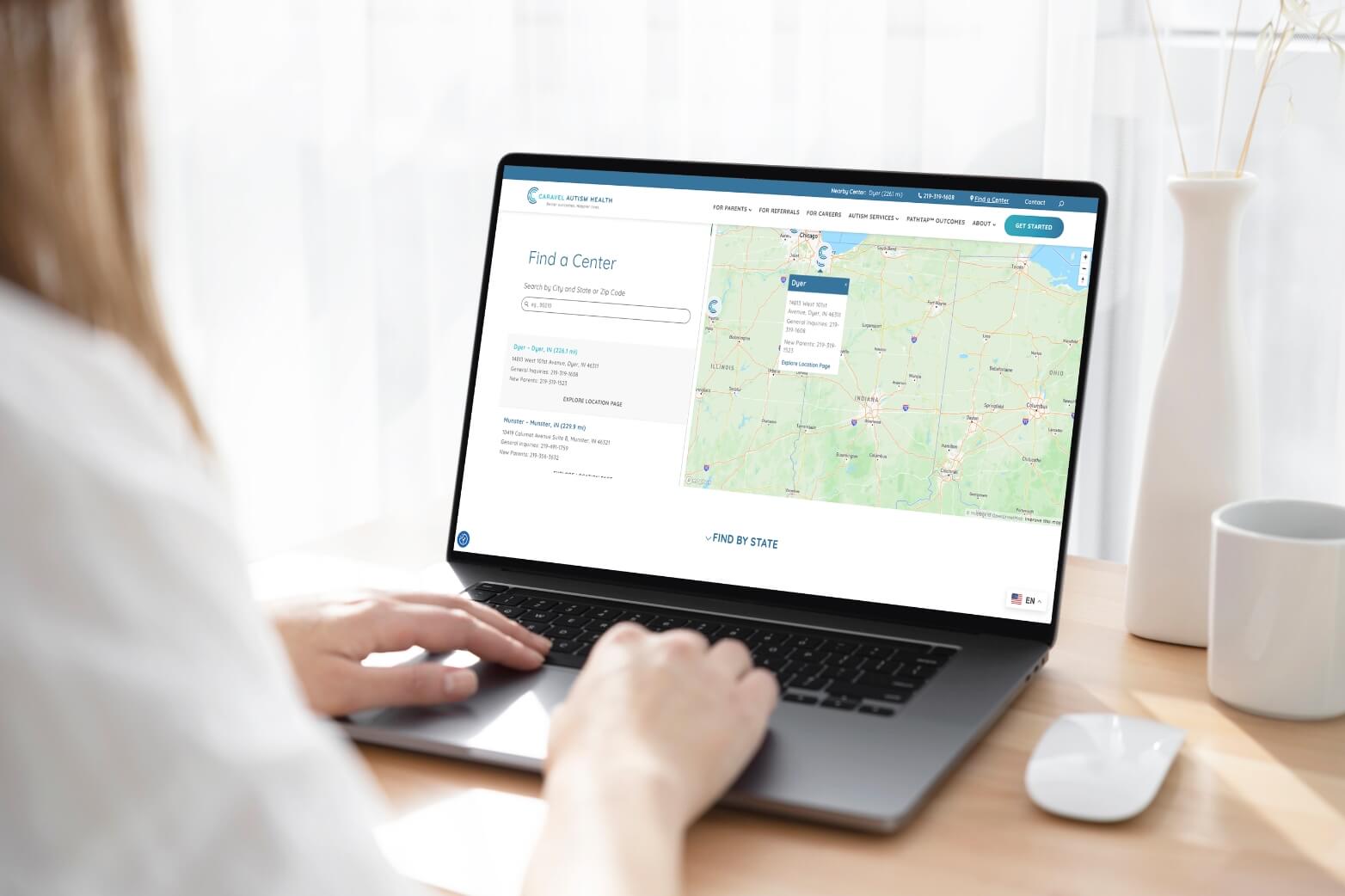 Person using a laptop to find a center location on a map website.